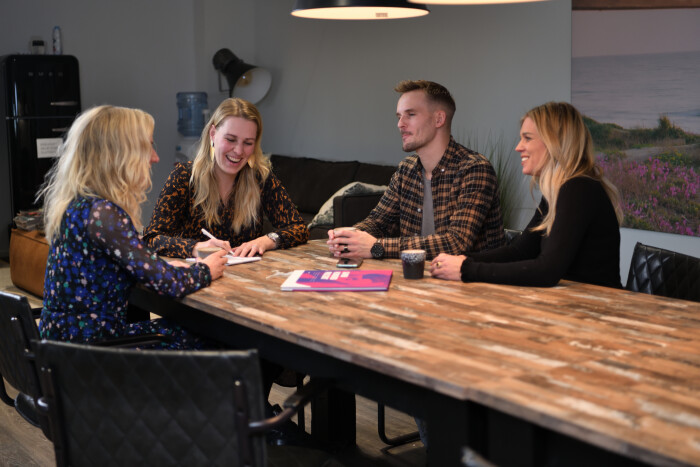 Collega's lachend met elkaar aan de koffietafel