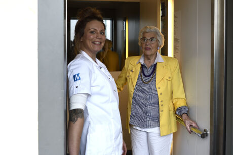 Verpleegkundige met oudere dame in de lift
